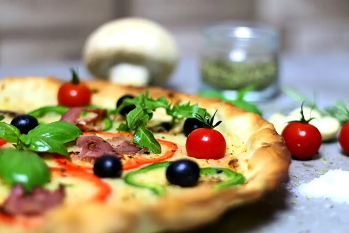 Pizza com rúcula, tomate cereja e azeitonas